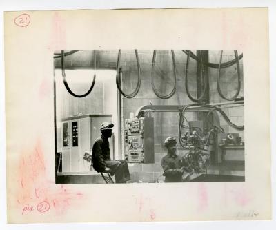 George Turner and Ronald De Cruz operating machinery